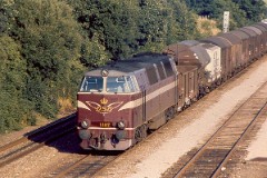 DSB MZ 1407 (type I) with freight train photographed in Fredericia August 1975.  The MZ class (type I and II) was purchased from 1967 to 1970 in a number of 26. Only a few of these engines remain in service by DSB - most are now sold to other companies. MZ 1407 was deposited in 2002. Built by NOHAB and Frichs. Dieselelectric. Co'Co'. 2270 kW - 3300 hp. Max speed 143 km/h - 89 mph. Length 20 800 mm. Weight 116,5 metric tonnes.